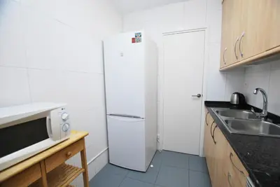 a small kitchen with a refrigerator and a sink at Premia Palm View in Premiá de Mar