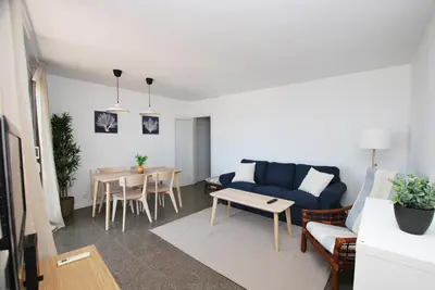 a living room with a blue couch and a table at Premia Palm View in Premiá de Mar
