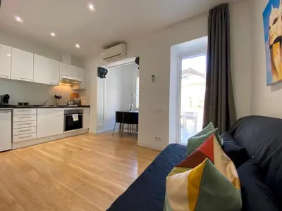 a living room with a couch and a kitchen at PISO FILIPPO in Barcelona