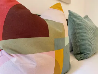 two colorful pillows sitting on top of a bed at PISO FILIPPO in Barcelona