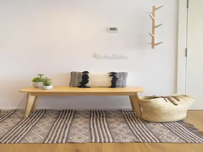 a wooden bench sitting on a rug in a room at Seafront Apartment in Calella with Beach Access in Calella
