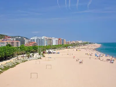 a beach with a lot of people and the ocean at Seafront Apartment in Calella with Beach Access in Calella