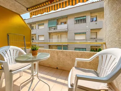 a balcony with a table and chairs and a building at Beachfront gateway in Pineda de Mar in Pineda de Mar