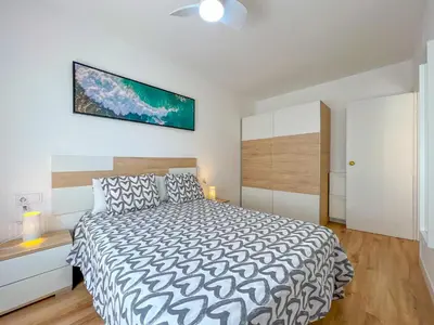 a bedroom with a bed and a tv on the wall at Beachfront gateway in Pineda de Mar in Pineda de Mar