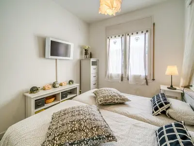 a bedroom with a bed with pillows and a television at Apartment in Calella near the Beach in Calella