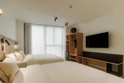a bedroom with two beds and a flat screen tv at Design Suites by Olala Homes in Hospitalet de Llobregat