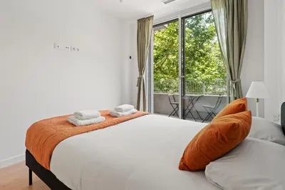 a bedroom with a bed with orange pillows and a window at Monthly 32 Nights 1BR Pools Parking in Barcelona