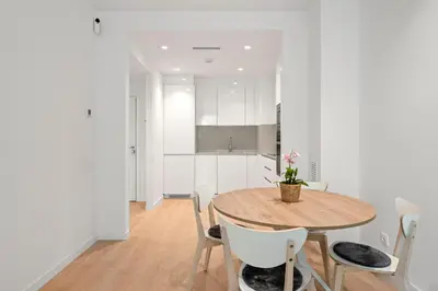 a kitchen and dining room with a wooden table and chairs at Monthly 32 Nights 1BR Pools Parking in Barcelona