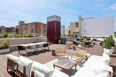 a rooftop patio with tables and chairs on a building at Monthly 32 Nights 1BR Pools Parking in Barcelona
