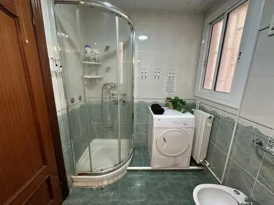 a small kitchen with white cabinets and a counter top at Habitaciones en la calle Valencia in Barcelona