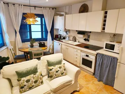 a living room with a couch and a kitchen at Blue Home in Sitges