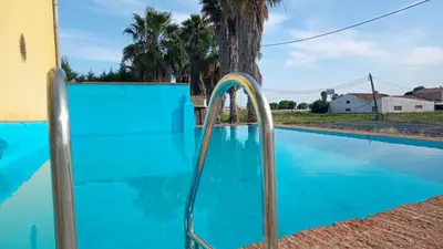 a blue swimming pool with a water hose in it at TURISME RURAL HORTA del PI in Cabrera de Mar