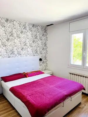 a bedroom with a white bed with a purple blanket at Large townhouse in St Cugat in Sant Cugat del Vallès