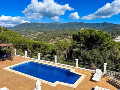 a swimming pool on a patio with mountains in the background at Tranquil Villa with Private Pool & views in Sant Cebrià de Vallalta