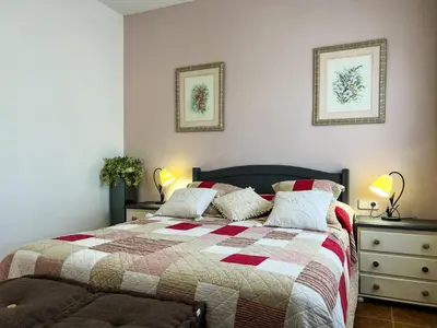 a bedroom with a bed with a quilt and two lamps at Tranquil Villa with Private Pool & views in Sant Cebrià de Vallalta