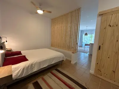 a bedroom with a bed and a door to a kitchen at Son Roca Ribes Guest House in Sant Pere de Ribes