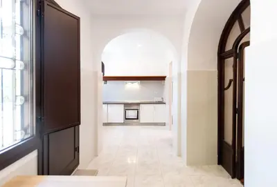 an empty hallway with a black door and a window at Unique 16th-Century Masia, Pool & Private Events in Barcelona