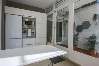 a kitchen with a white table and a window at Provenza Flat in Barcelona