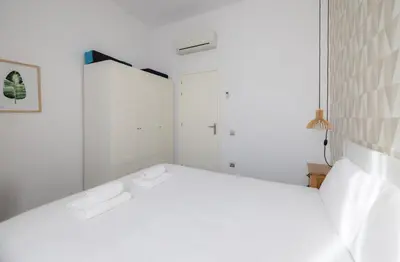 a white bathroom with white walls and a mirror at Stay U-nique Apartment Republica Argentina in Barcelona