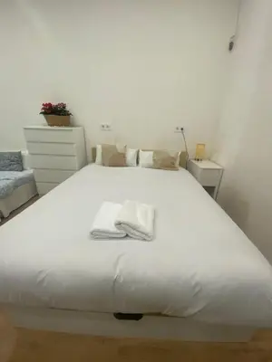 a white bed with two towels on top of it at Barcelona Home in Barcelona