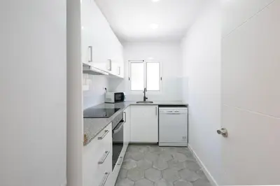a white kitchen with a sink and a dishwasher at Lovely apartment with 3 bedroom in Cornellà de Llobregat