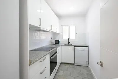 a white kitchen with white cabinets and a sink at Lovely apartment with 3 bedroom in Cornellà de Llobregat