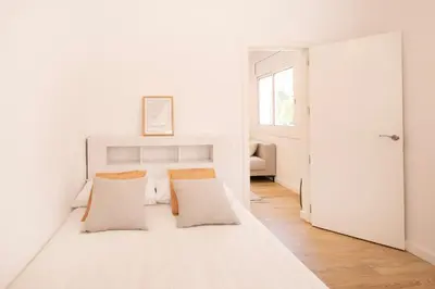 a white bedroom with a bed with two pillows at Lovely apartment with 3 bedroom in Cornellà de Llobregat