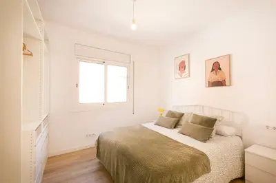 a white bedroom with a bed and a window at Lovely apartment with 3 bedroom in Cornellà de Llobregat