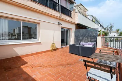 a patio with a wooden bench and a balcony at Flateli Calàbria in Barcelona