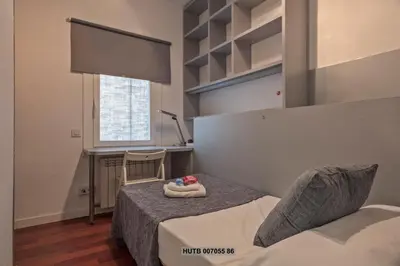 a bedroom with a bed and a desk and a window at Alcam Augusta in Barcelona