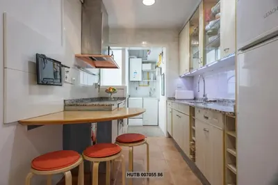 a kitchen with a counter and stools in it at Alcam Augusta in Barcelona