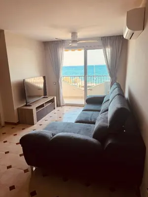 a living room with a couch and a view of the beach at Apartamento en 1ª línea con vistas al mar cerca de Barcelona in Pineda de Mar