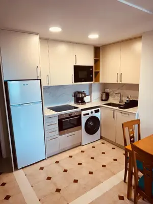 a kitchen with a white refrigerator and a dishwasher at Apartamento en 1ª línea con vistas al mar cerca de Barcelona in Pineda de Mar