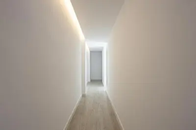 an empty hallway with white walls and wooden floors at Bright & Stylish Flat In Trendy Grcia in Barcelona