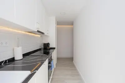 a kitchen with white cabinets and black counter tops at Bright & Stylish Flat In Trendy Grcia in Barcelona