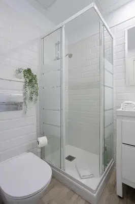 a white bathroom with a shower and a toilet at Bright & Stylish Flat In Trendy Grcia in Barcelona