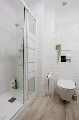 a white bathroom with a shower and a toilet at Bright & Stylish Flat In Trendy Grcia in Barcelona
