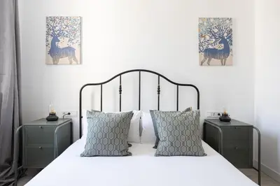 a bedroom with a white bed with two night stands at Bright & Stylish Flat In Trendy Grcia in Barcelona