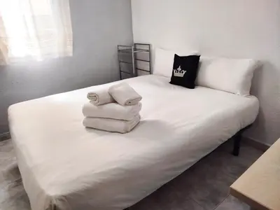 a white bed with towels on top of it at La Habitación de Santa Eulalia habitación privada in Hospitalet de Llobregat
