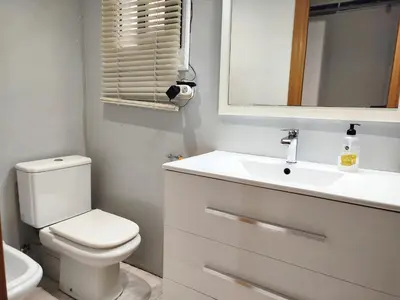 a bathroom with a toilet and a sink and a mirror at La Habitación de Santa Eulalia habitación privada in Hospitalet de Llobregat