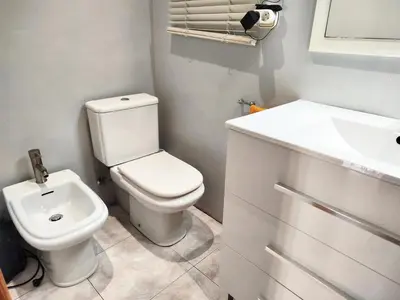 a bathroom with a white toilet and a sink at La Habitación de Santa Eulalia habitación privada in Hospitalet de Llobregat