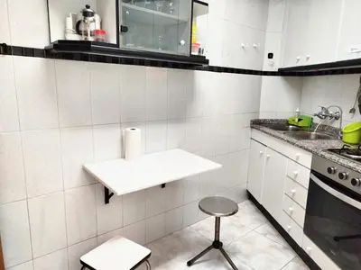 a white kitchen with a sink and a stool at La Habitación de Santa Eulalia habitación privada in Hospitalet de Llobregat