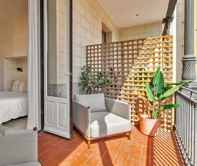a porch with a chair and a bed on a balcony at The Boulevard by Aspasios in Barcelona