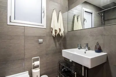 a bathroom with a white sink and a mirror at Housalia Ondina Suites Sagrada Familia in Barcelona