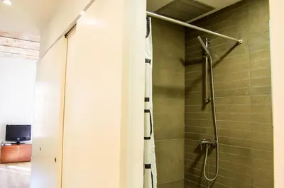 a shower with a glass door in a bathroom at Housalia Ondina Suites Sagrada Familia in Barcelona