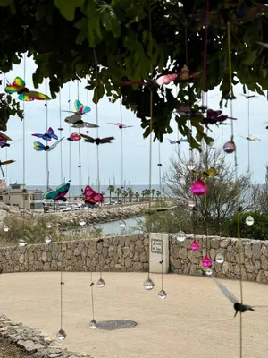 a group of kites flying in the air over a wall at Quiet Apartment in Sitges Center Steps from Beach in Sitges