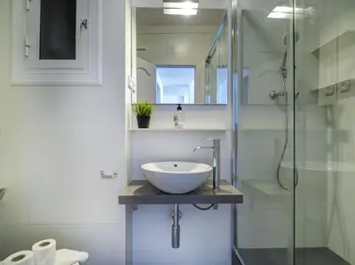 a bathroom with a sink and a glass shower at Warm Sands Apartment by Hello Homes Sitges in Sitges