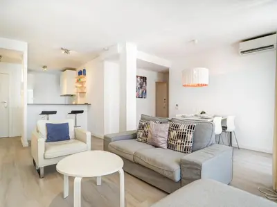 a living room with a couch and a chair and a table at Warm Sands Apartment by Hello Homes Sitges in Sitges