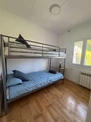 a bedroom with two bunk beds and a wooden floor at Vila Viva Mundo in San Cipriano de Vallalta