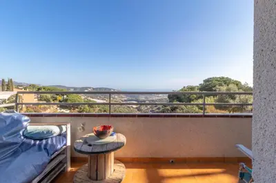 a balcony with a bed and a table with a view at Vila Viva Mundo in San Cipriano de Vallalta